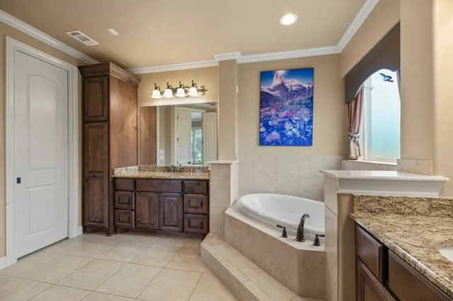 a bathroom with a granite countertop tub sink and mirror