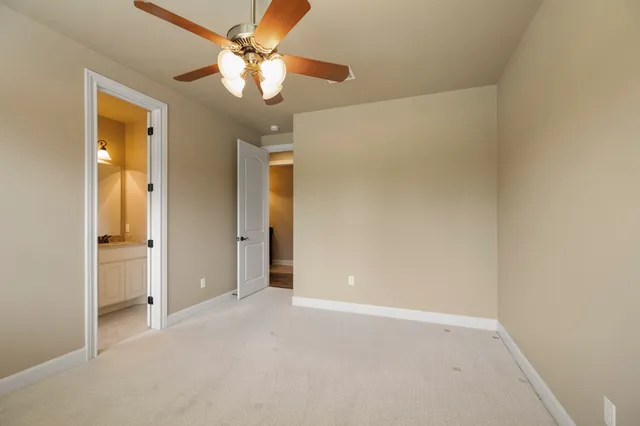 an empty room with a ceiling fan and a window