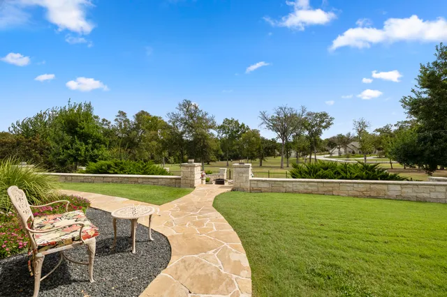 a view of a swimming pool with lawn chairs and a table