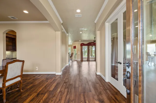 a view of a hallway with wooden floor and glass door