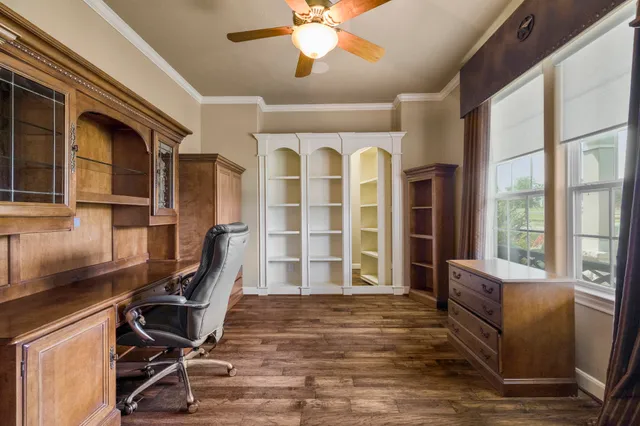 a view of a workspace with furniture and a window