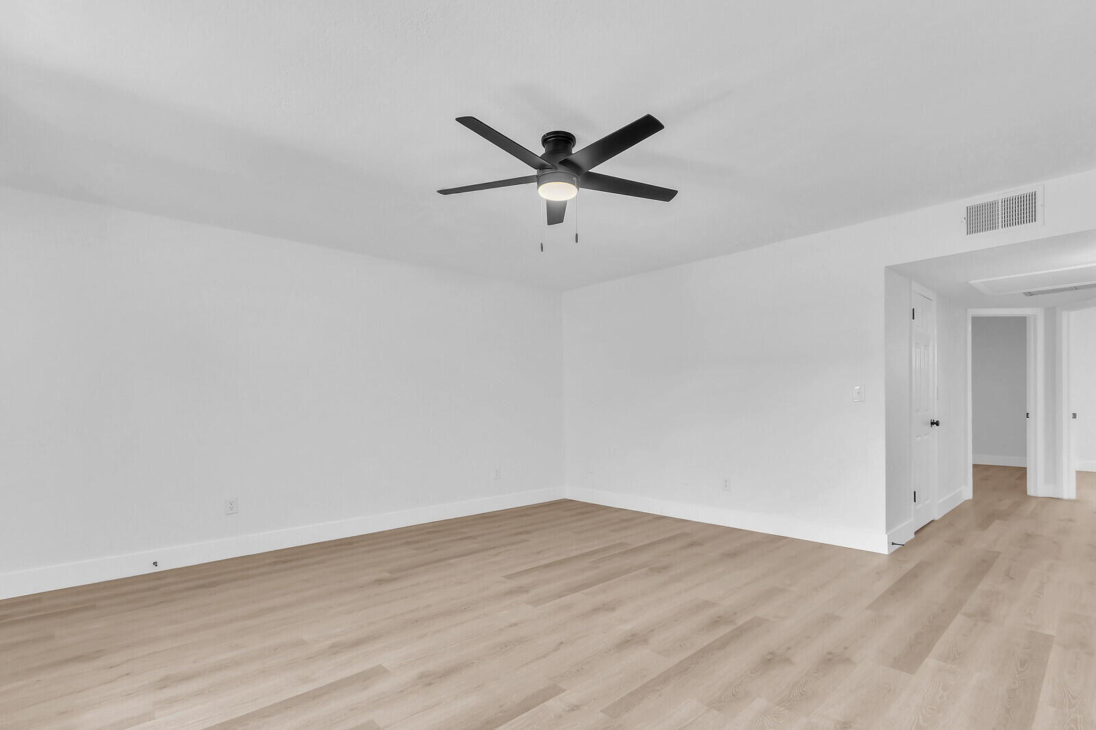 2929 Southeast Ocean Boulevard, Unit E1 Stuart, FL 34996 - Photo 11 of 37 a view of a big room with wooden floor and a ceiling fan