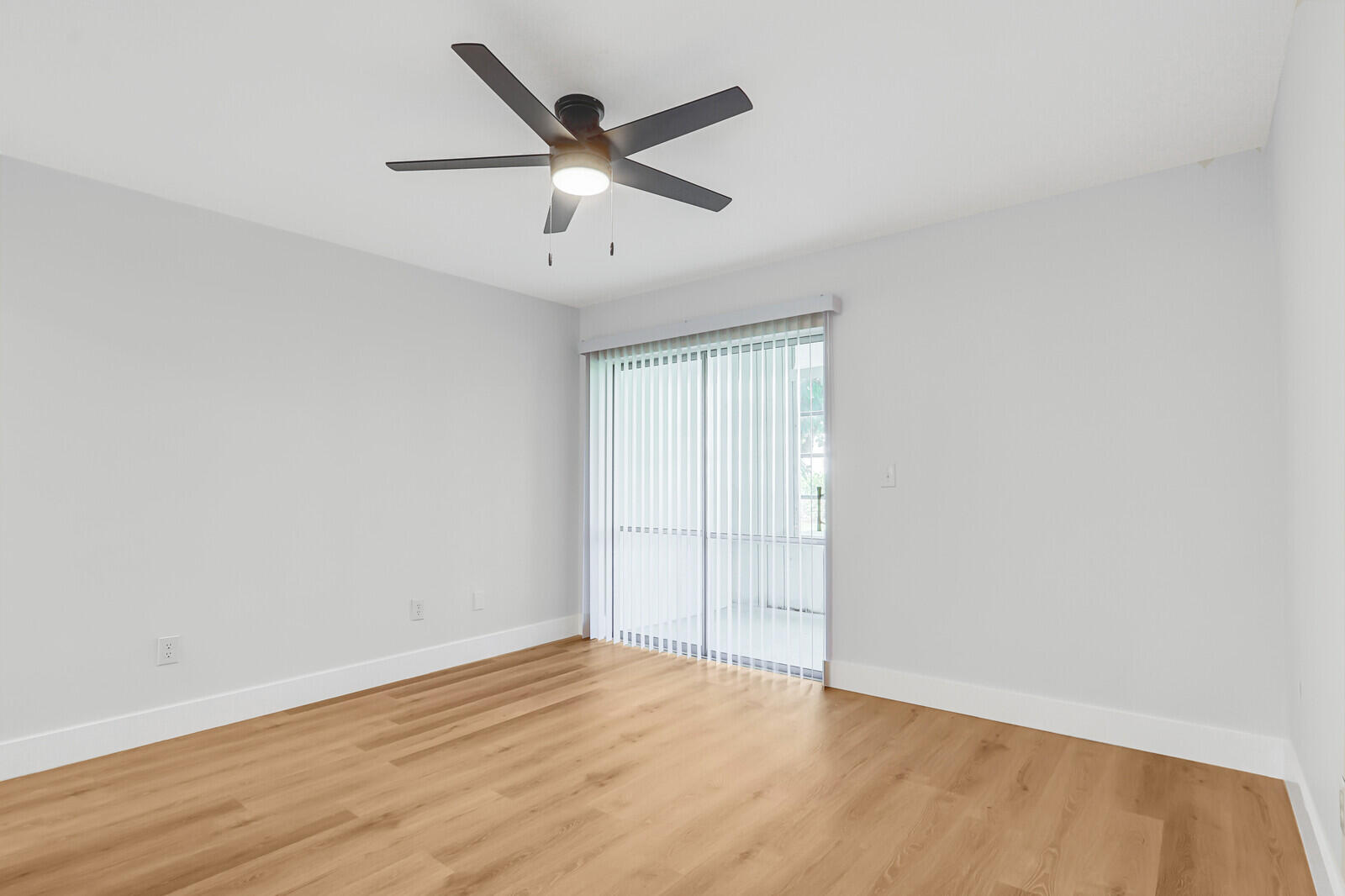 2929 Southeast Ocean Boulevard, Unit E1 Stuart, FL 34996 - Photo 18 of 37 an empty room with wooden floor and ceiling fan