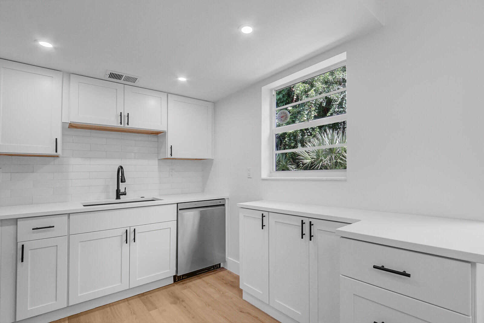 2929 Southeast Ocean Boulevard, Unit E1 Stuart, FL 34996 - Photo 6 of 37 a kitchen with white cabinets and window