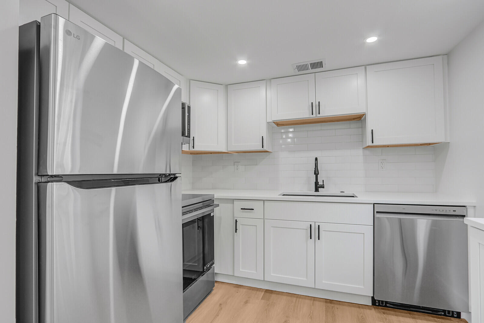 2929 Southeast Ocean Boulevard, Unit E1 Stuart, FL 34996 - Photo 7 of 37 a kitchen with white cabinets and stainless steel appliances