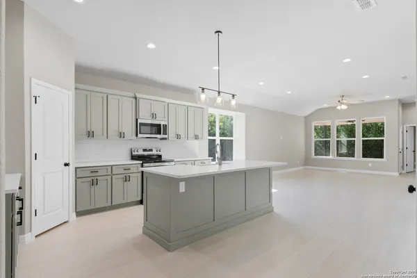 a kitchen with kitchen island granite countertop a stove and a sink
