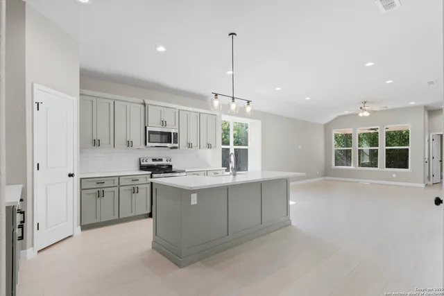 a kitchen with kitchen island granite countertop a stove and a sink