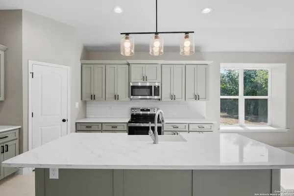 a kitchen with kitchen island a counter space a sink and appliances