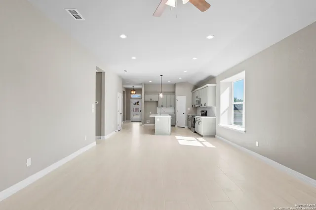 a view of a kitchen with refrigerator and windows