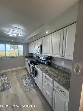 a kitchen with granite countertop a sink and a stove