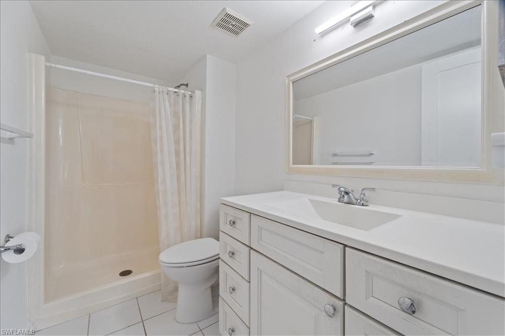 307 Goodlette-Frank Road, Unit B202 Naples, FL 34102 - Photo 21 of 32 a bathroom with a granite countertop sink a toilet and a mirror