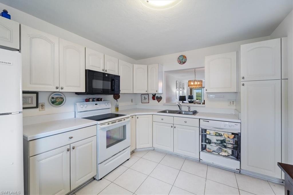 307 Goodlette-Frank Road, Unit B202 Naples, FL 34102 - Photo 29 of 32 a kitchen with cabinets stainless steel appliances and a sink