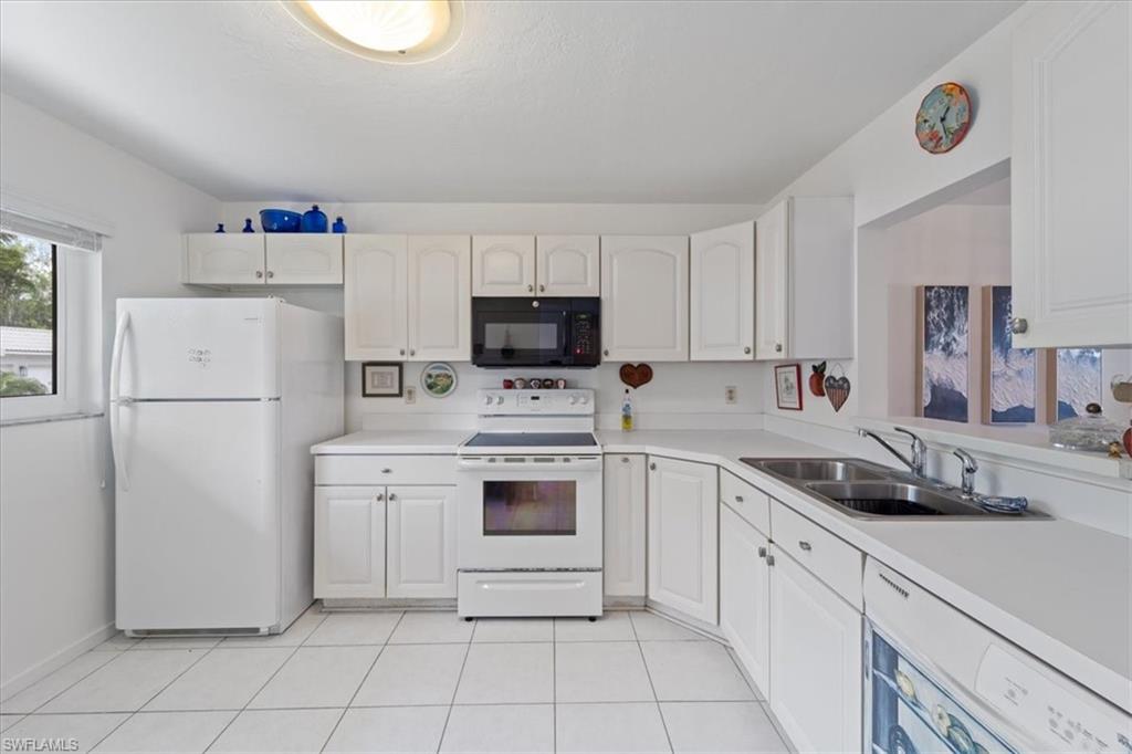 307 Goodlette-Frank Road, Unit B202 Naples, FL 34102 - Photo 30 of 32 a kitchen with a refrigerator sink and cabinets