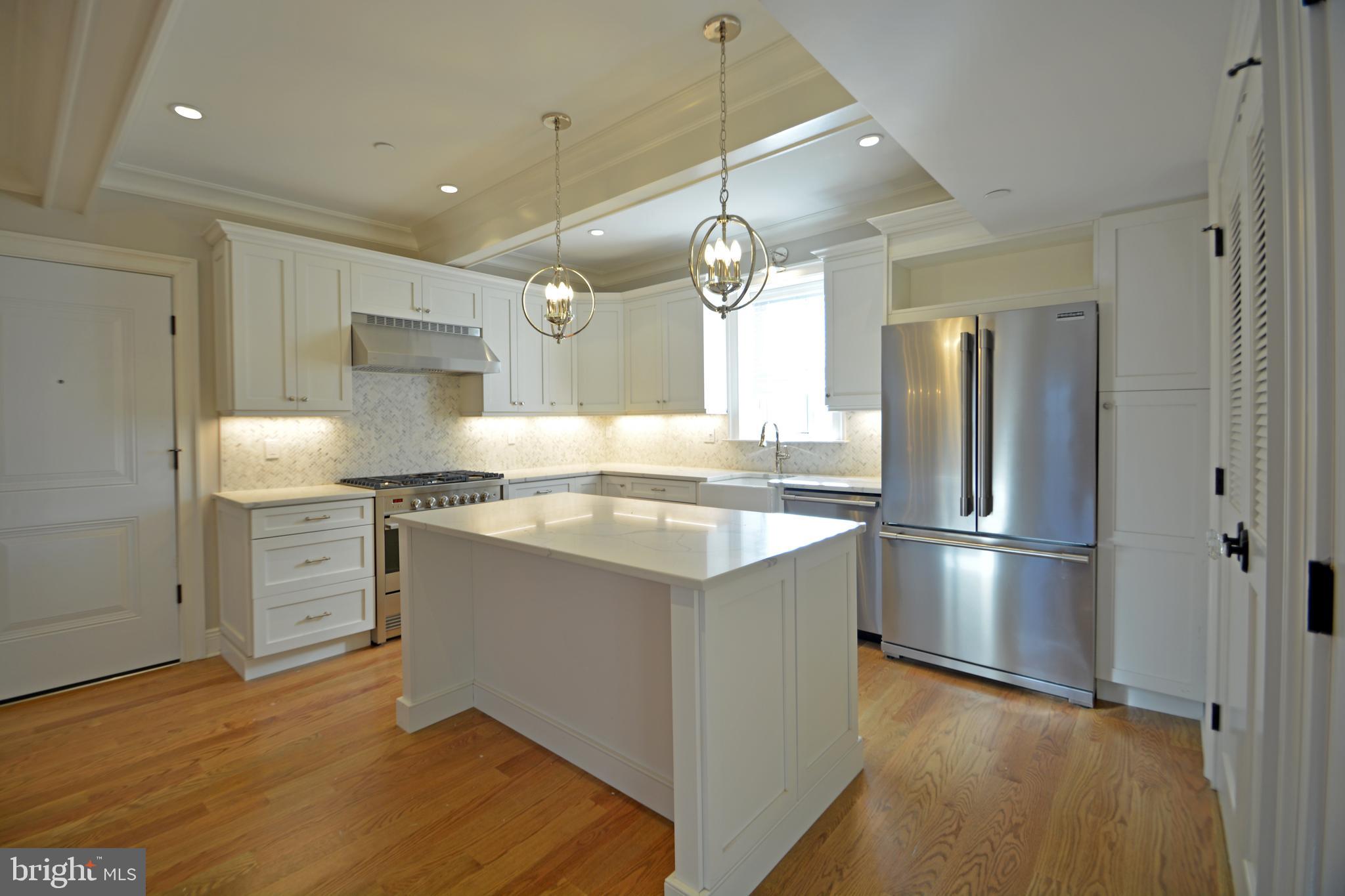 a kitchen with kitchen island granite countertop a sink appliances and cabinets