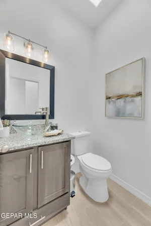 a bathroom with a granite countertop toilet a sink and mirror