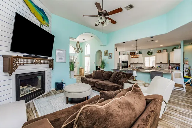 a living room with furniture a flat screen tv and a fireplace