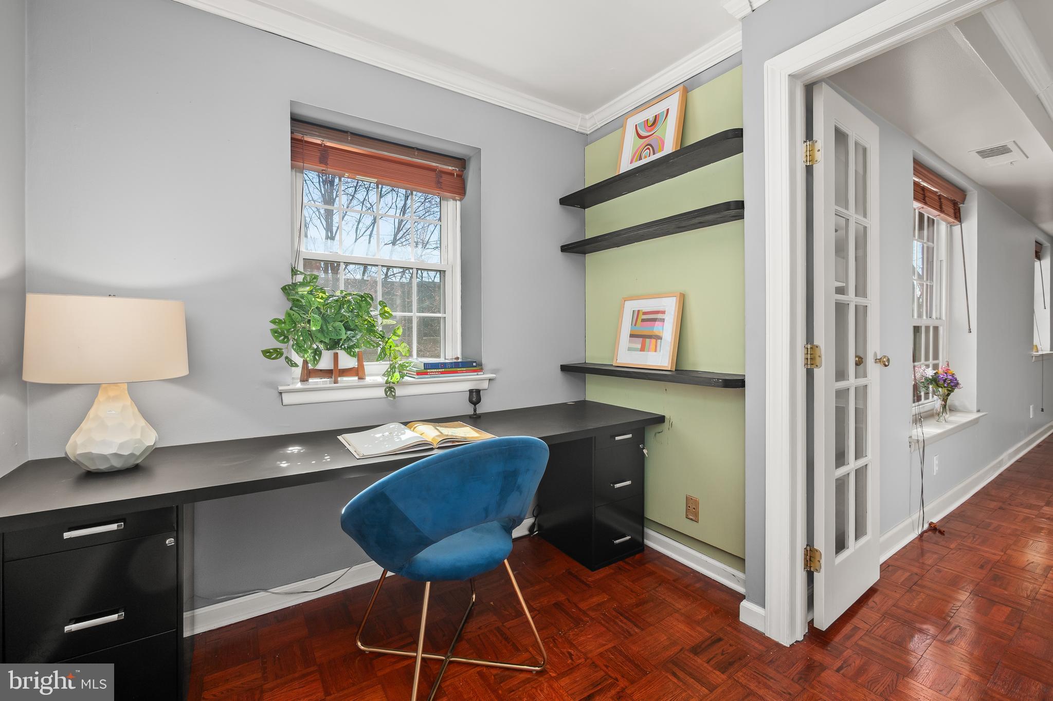 a view of a workspace with furniture and a window
