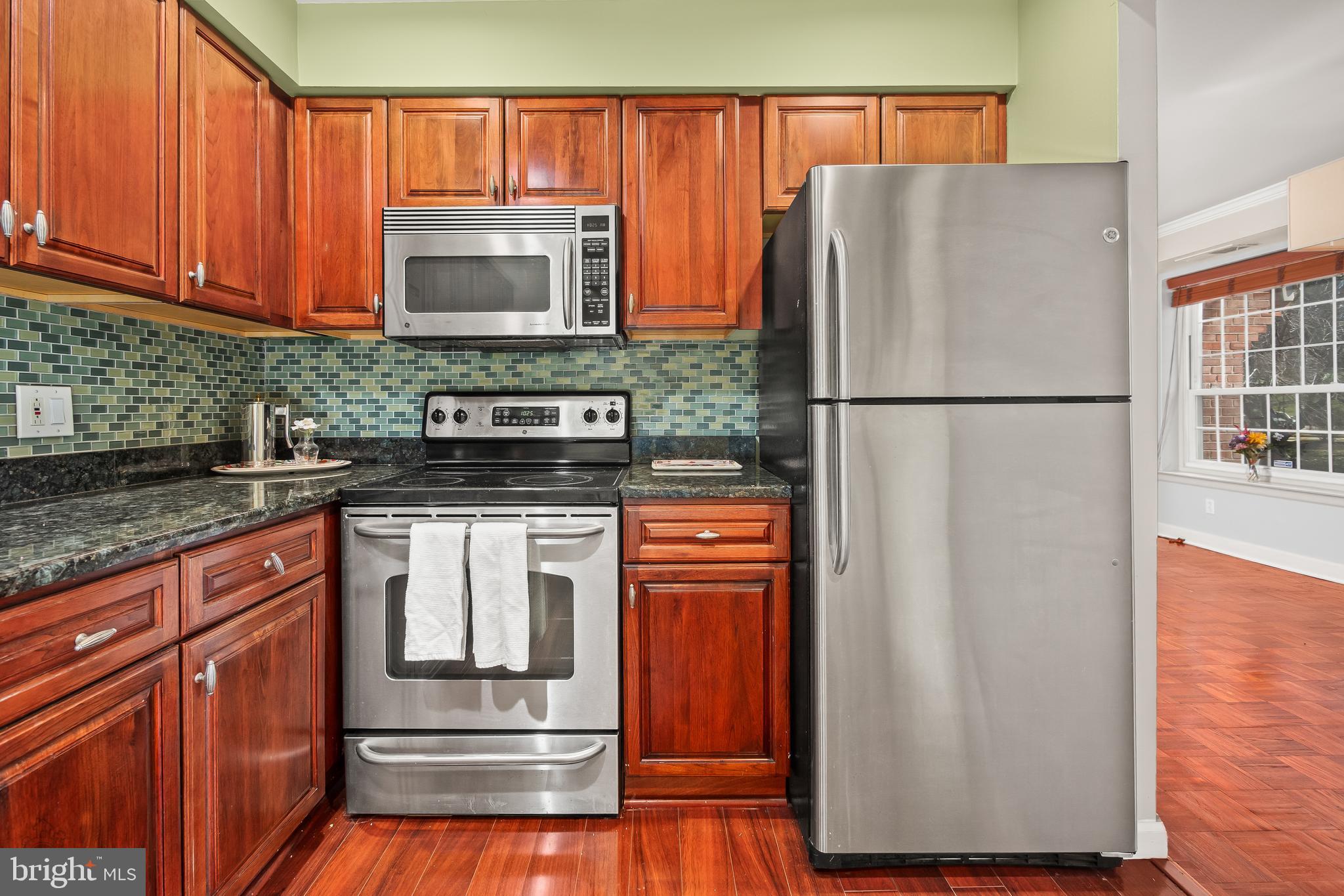 4000 Gypsy Lane, Unit 210 Philadelphia, PA 19129 - Photo 16 of 35 a kitchen with stainless steel appliances granite countertop a refrigerator and a stove top oven