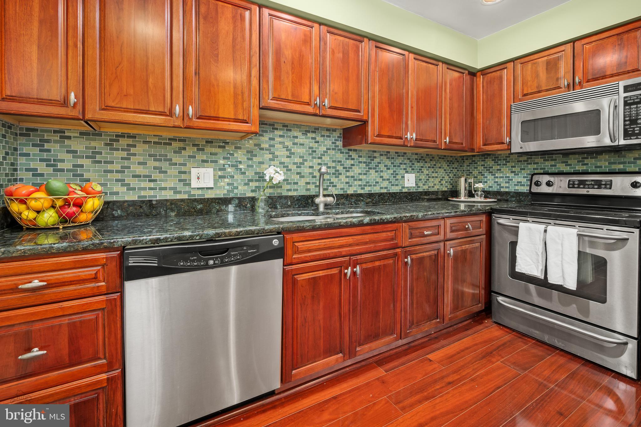 4000 Gypsy Lane, Unit 210 Philadelphia, PA 19129 - Photo 5 of 35 a kitchen with stainless steel appliances granite countertop wooden cabinets a stove and a sink