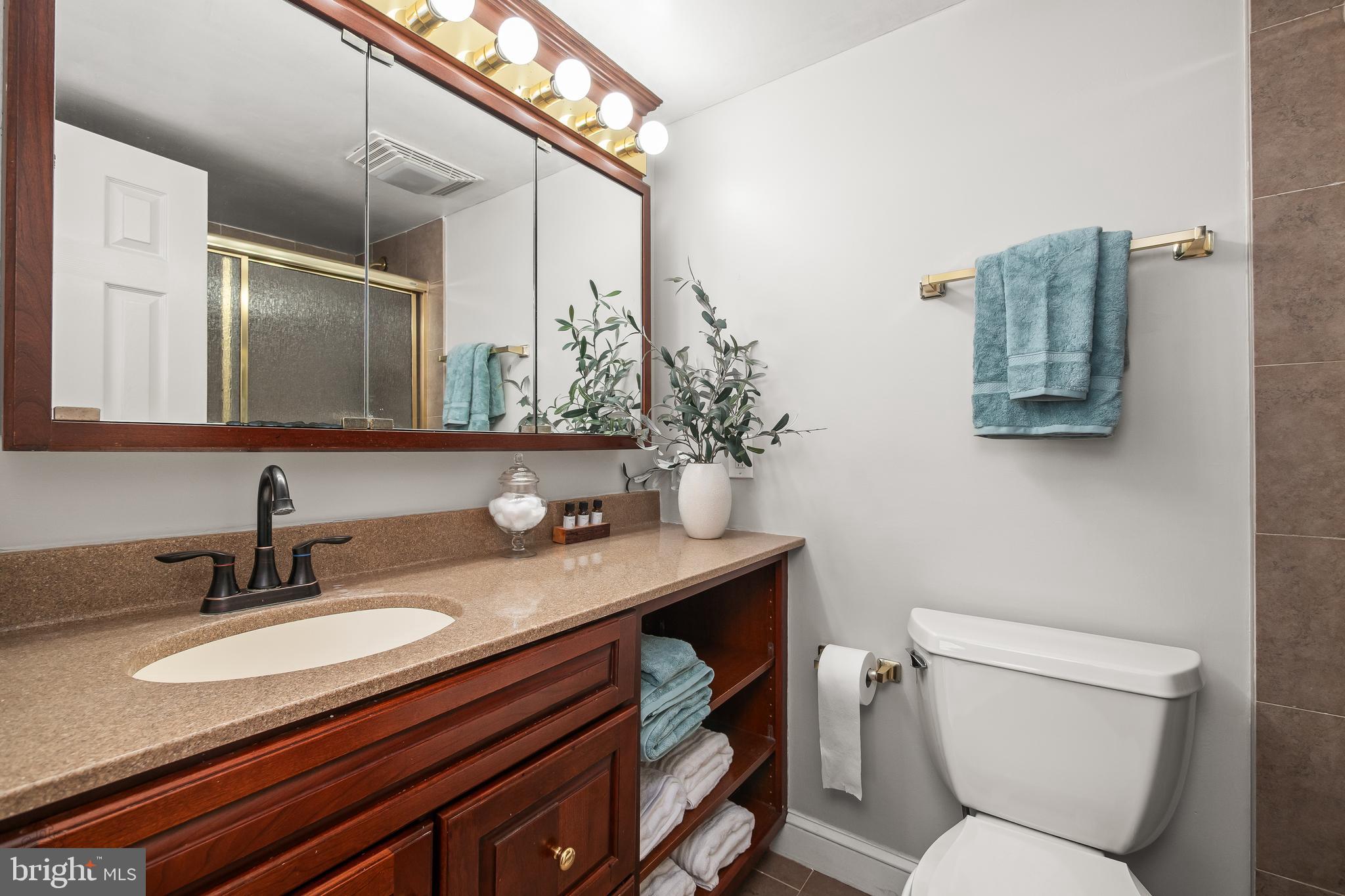 4000 Gypsy Lane, Unit 210 Philadelphia, PA 19129 - Photo 9 of 35 a bathroom with a granite countertop toilet sink and mirror