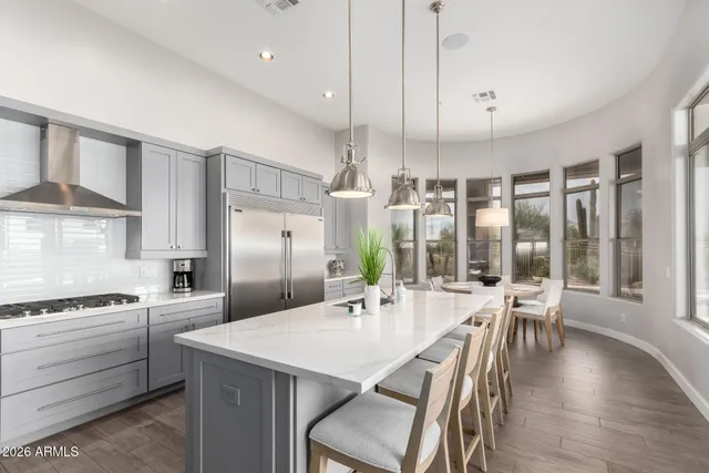 a large bed in a bedroom next to a window and a wooden floor