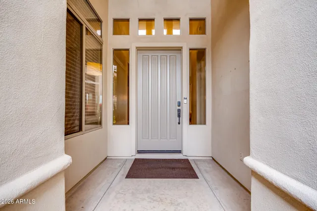 a dining room with wooden floor a chandelier a glass table and chairs