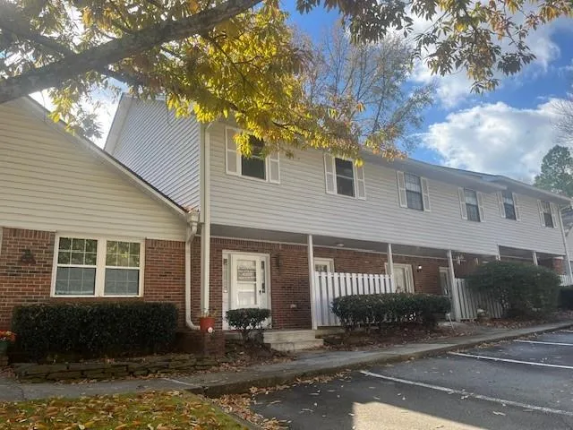 a front view of a house with a tree in front