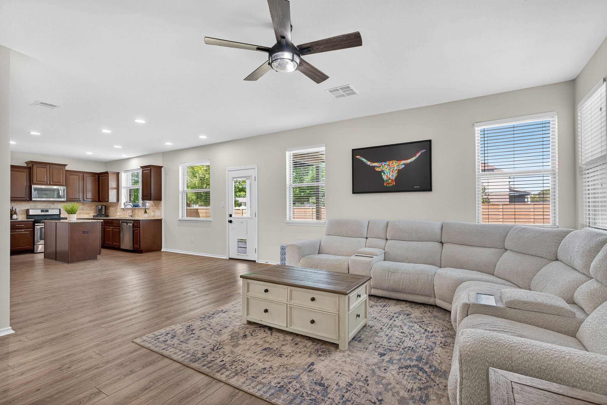 13300 Craven Lane Manor, TX 78653 - Photo 11 of 40 Plenty of natural light, luxury vinyl plank floors, ceiling fan, and recessed lighting. Oversized living room opens up to the kitchen.