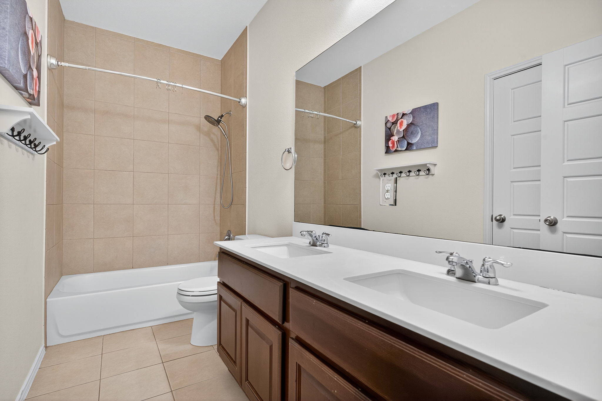 13300 Craven Lane Manor, TX 78653 - Photo 20 of 40 Secondary Bathroom with double vanity, shower combination, linen closet and light tile patterned floors