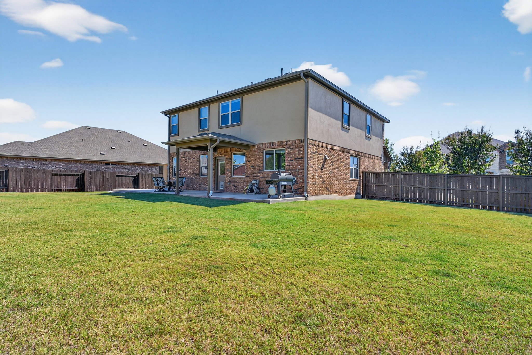 13300 Craven Lane Manor, TX 78653 - Photo 29 of 40 Rear view of house featuring a fenced backyard, brick siding, a patio area, and stucco siding