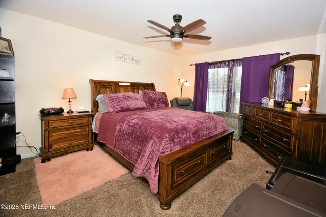 a spacious bedroom with a bed a dresser and potted plants