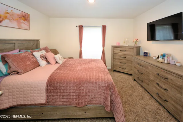 a bedroom with a bed and flat screen tv