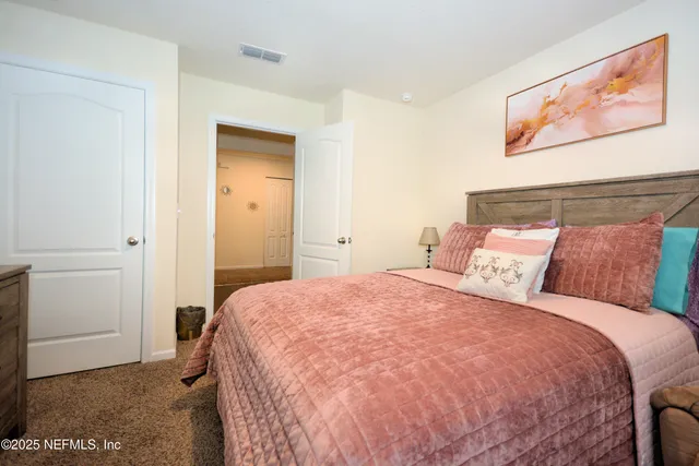 a bedroom with a bed and painting on the wall