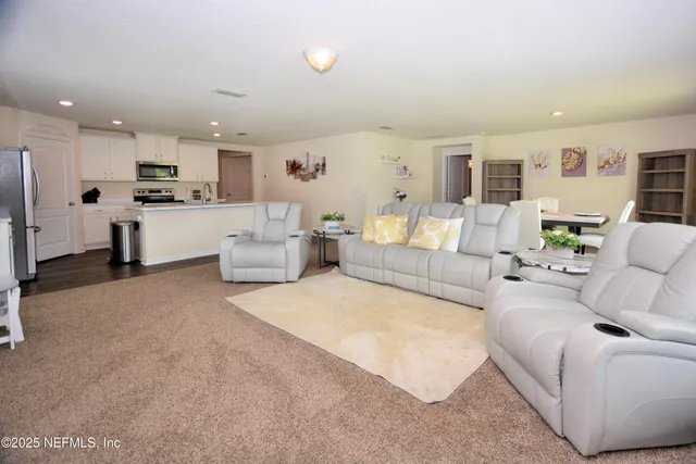 a living room with furniture and kitchen view