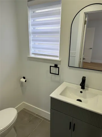 a bathroom with a sink a toilet a mirror and shower