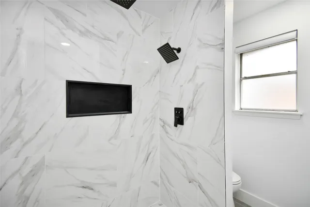 a living room with a flat screen tv a rug and white walls