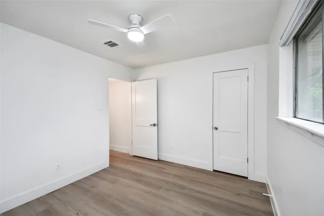 a view of an empty room with wooden floor