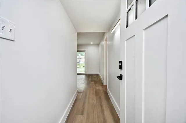 a view of a hallway with wooden floor and staircase
