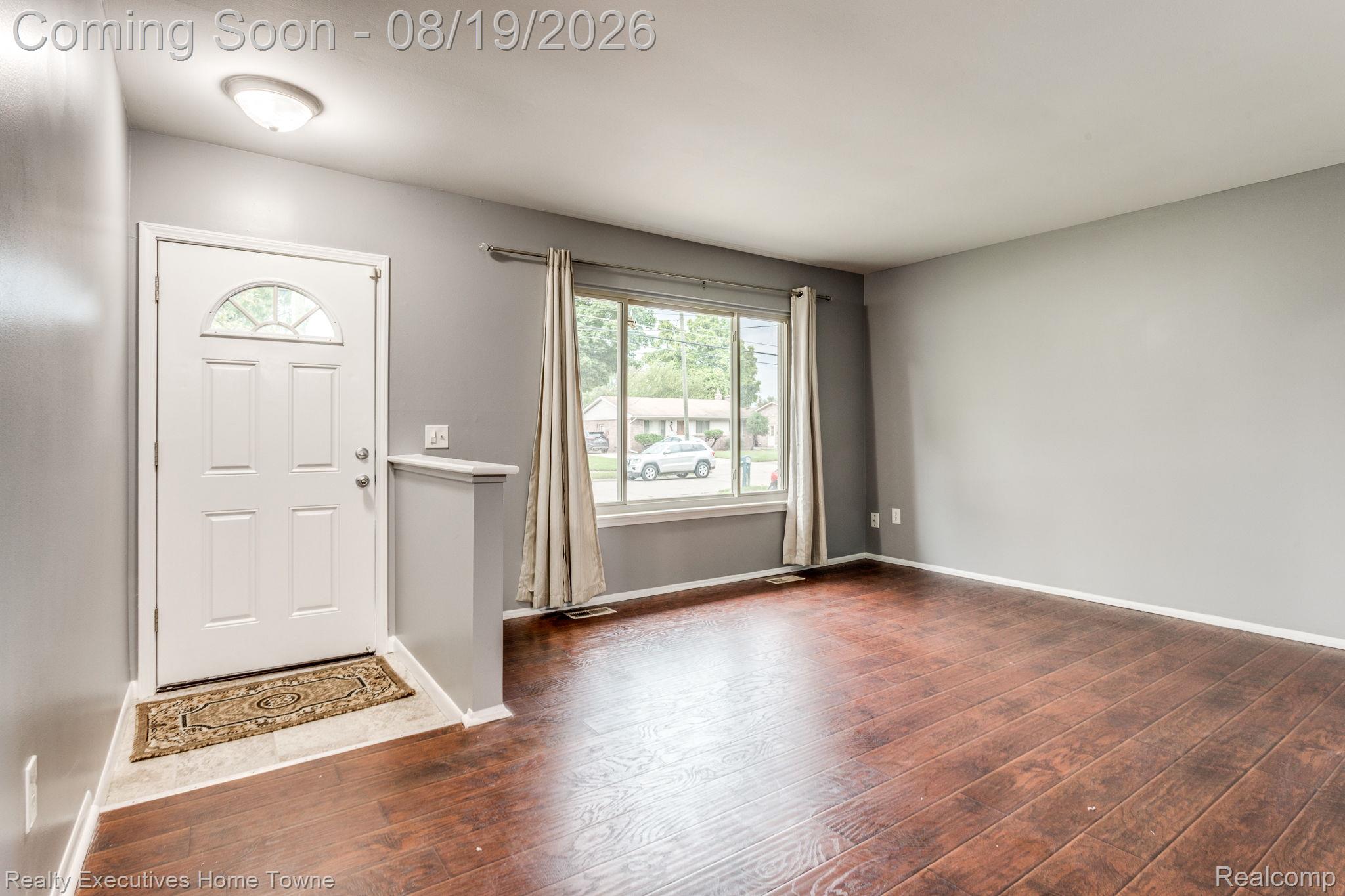 2448 Oakcrest Road Sterling Heights, MI 48310 - Photo 2 of 31 Wood-finish flooring, white trim, and a window with a streetscape beyond