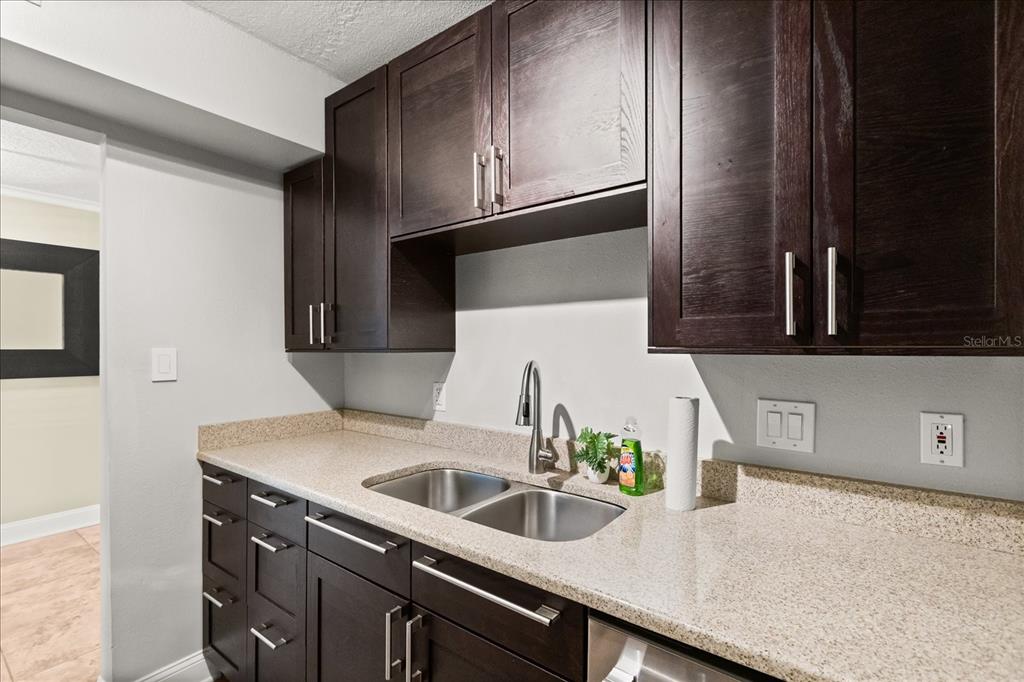 2500 Lee Road, Unit 122 Winter Park, FL 32789 - Photo 12 of 25 a kitchen with granite countertop a sink and a stove top oven