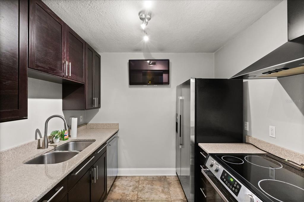 2500 Lee Road, Unit 122 Winter Park, FL 32789 - Photo 8 of 25 a kitchen with stainless steel appliances granite countertop a sink stove and refrigerator