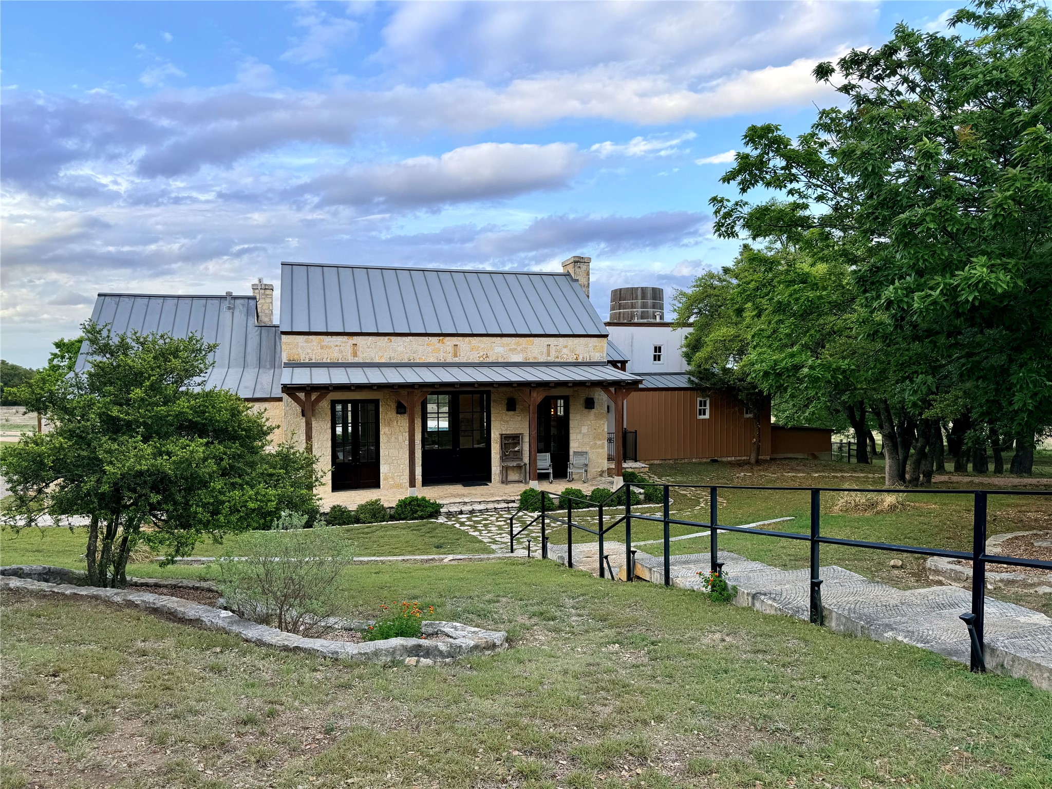 768 North Walnut Springs Road Johnson City, TX 78636 - Photo 17 of 22 The property features a stone exterior, a metal roof, and a covered patio area