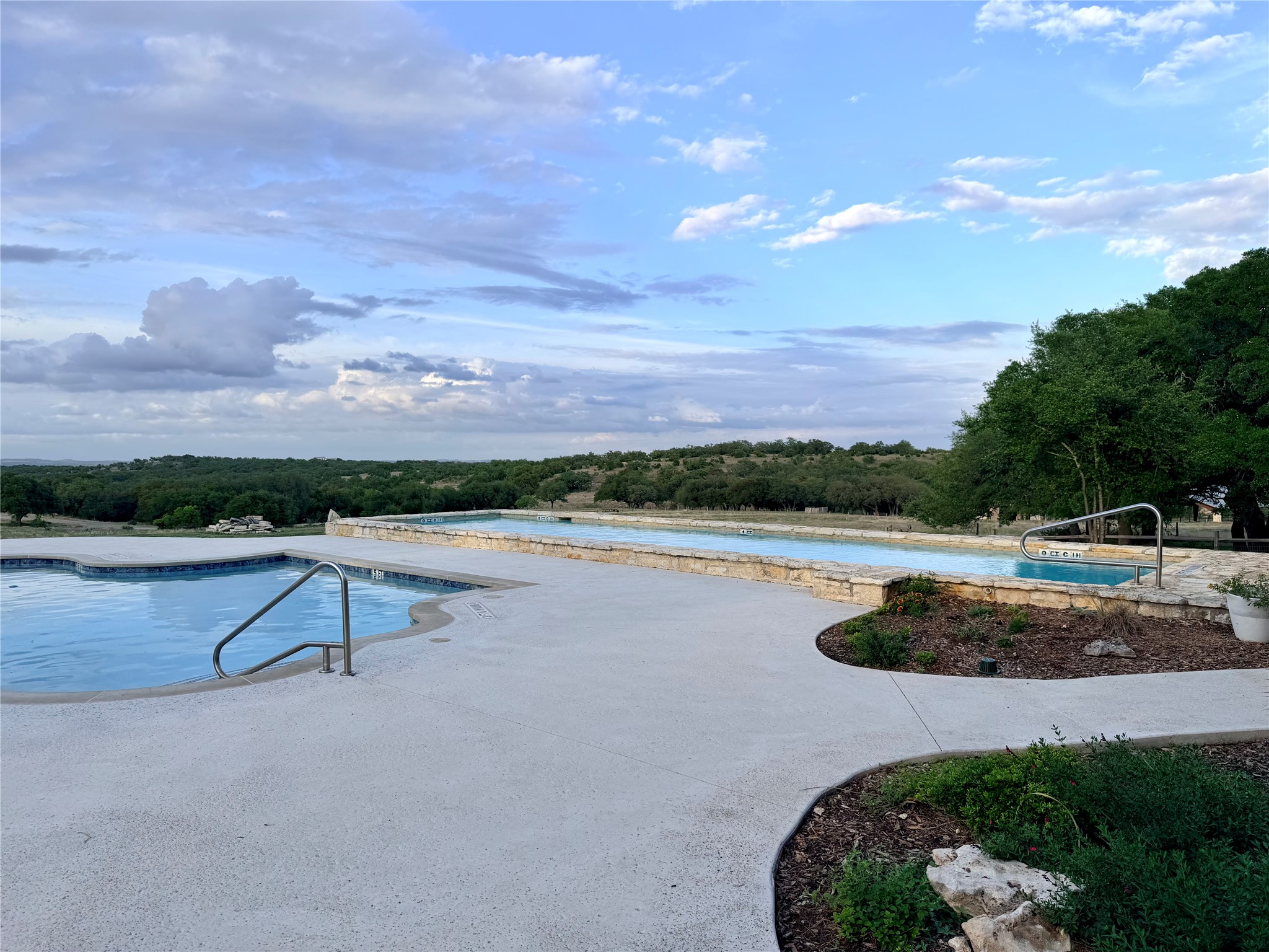 768 North Walnut Springs Road Johnson City, TX 78636 - Photo 19 of 22 The property features a swimming pool with a tile border, a separate hot tub, and a spacious concrete patio