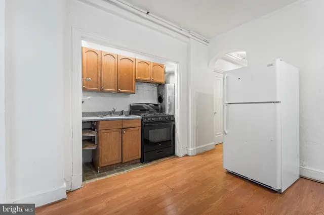 a kitchen with a refrigerator a stove top oven a sink and cabinets