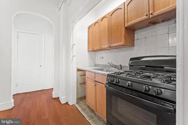 a kitchen with wooden floor and steel appliances