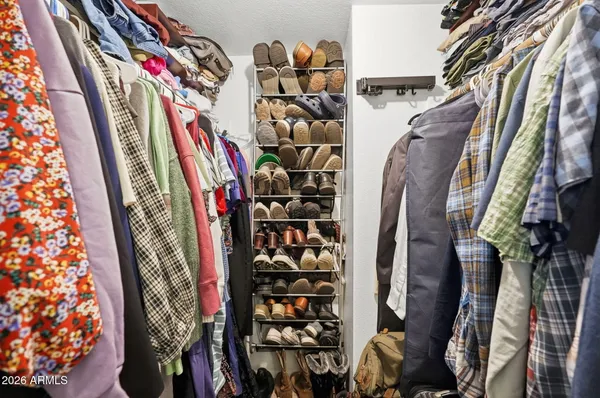 a view of walk in closet with clothes and shoes