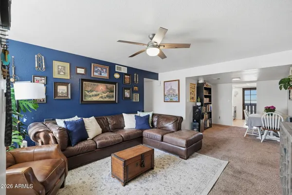 a living room with furniture and a ceiling fan
