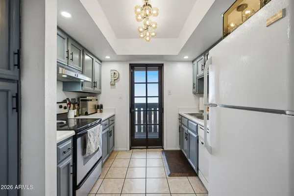 a kitchen with stainless steel appliances granite countertop a refrigerator a stove and a sink