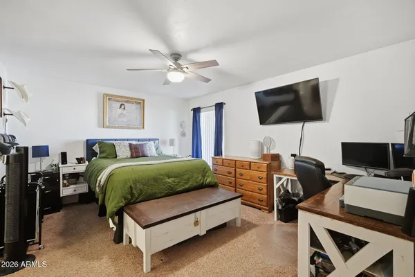 a spacious bedroom with a bed and a flat screen tv