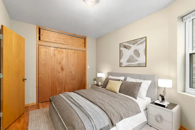 a bedroom with a bed and wooden floor